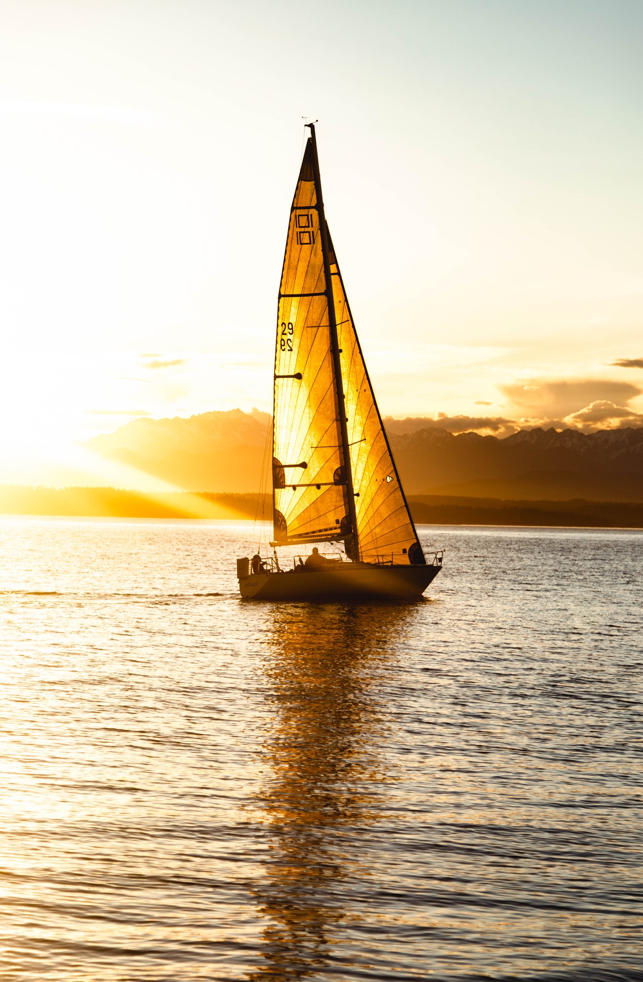 beautiful sailboat at sunset that is great example of a good sailboat for first-time sailboat owners